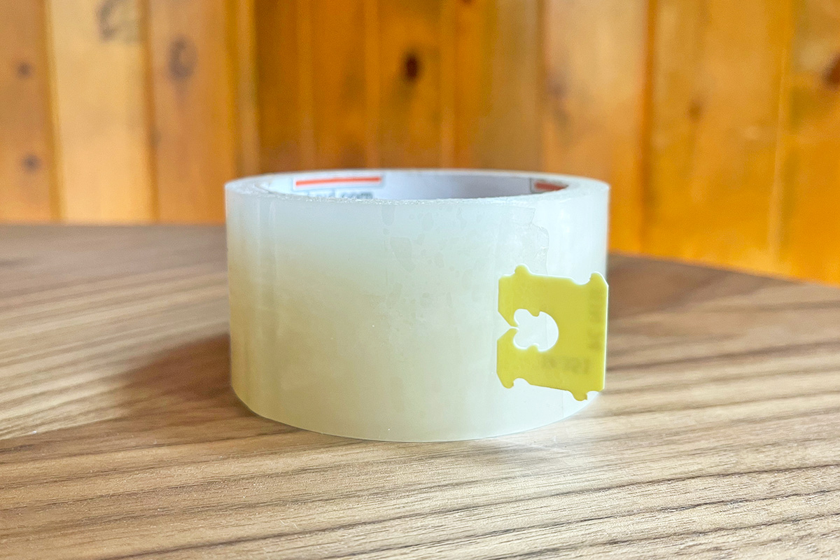 A roll of clear packing tape with a bread tag attached to the end, making it easier to find.