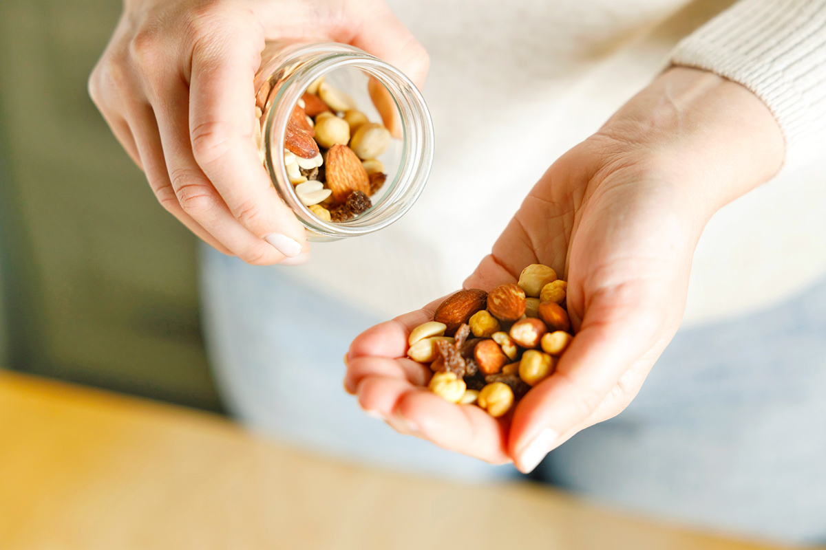 Nuts spilling from jar in woman's hand