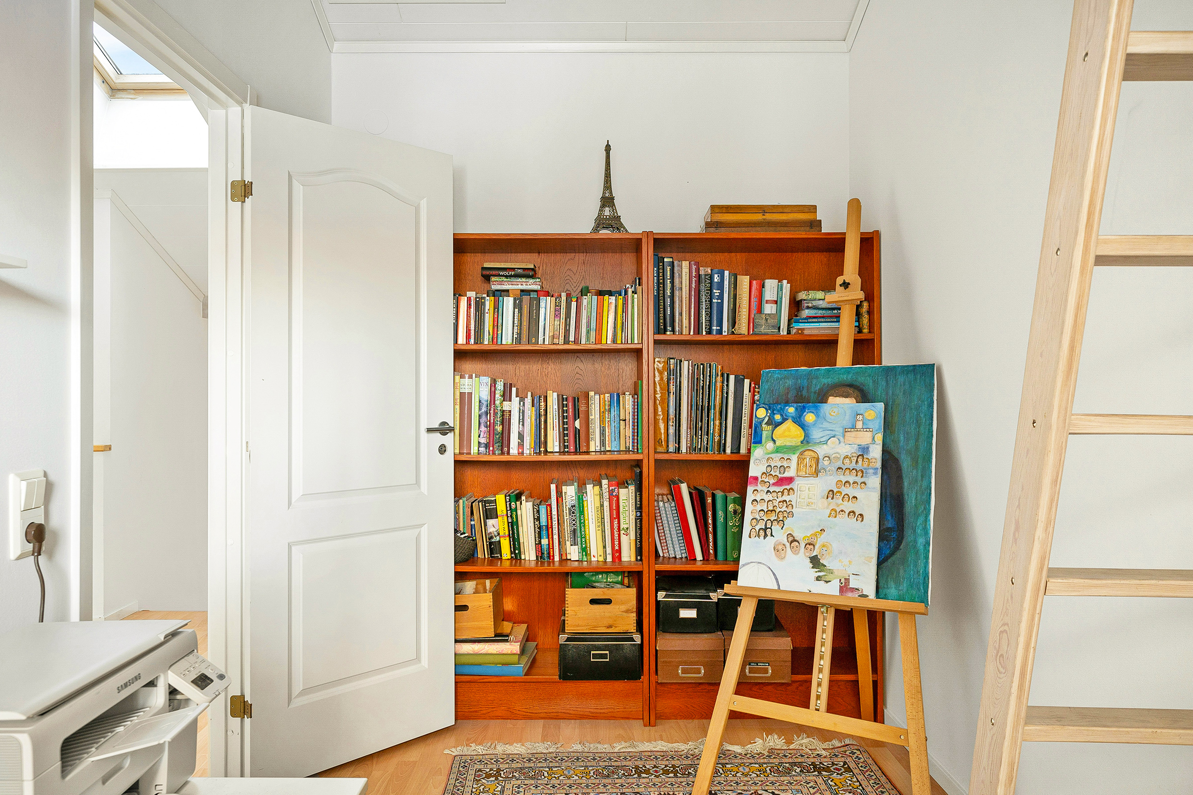View of a bookshelf and paintings inside a modern home