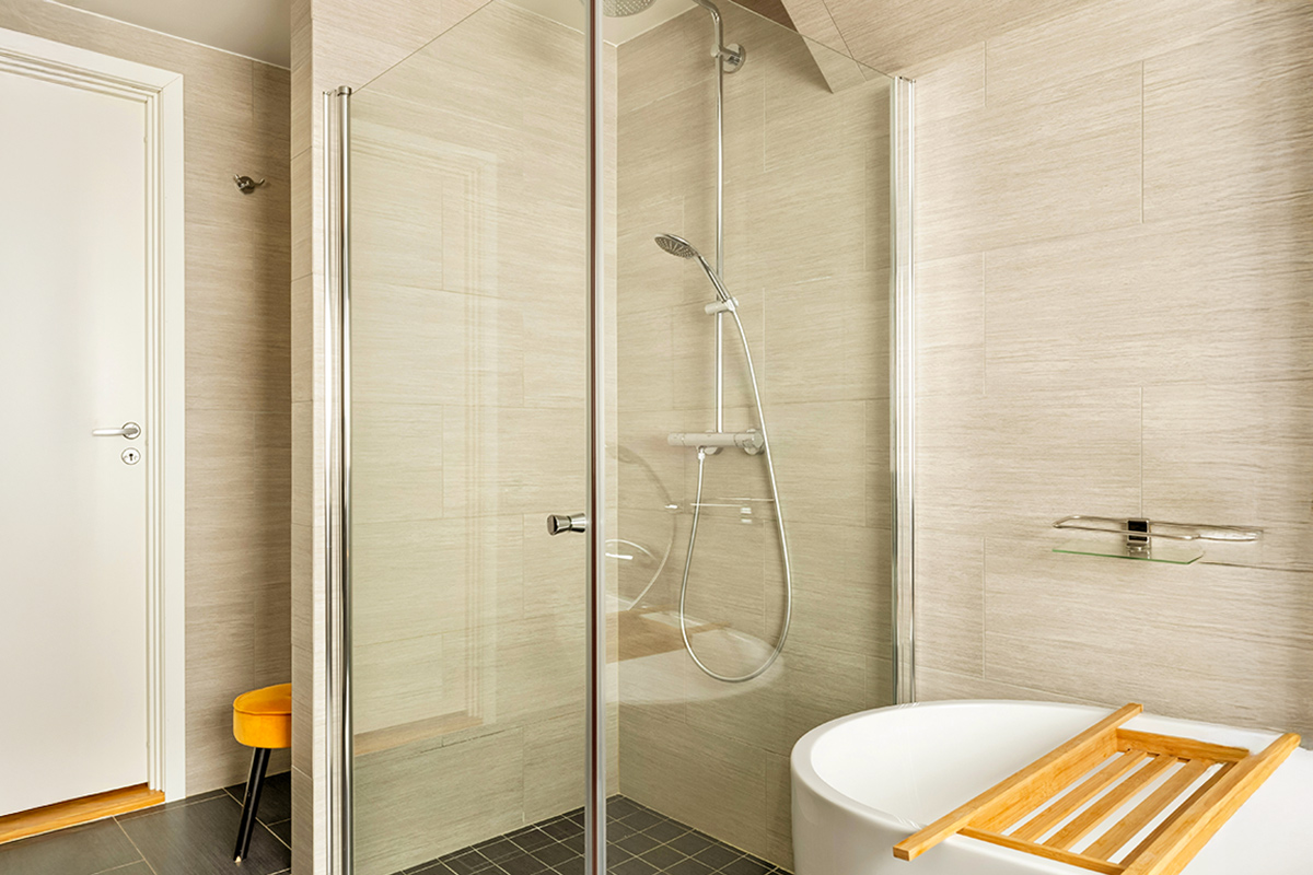 A very clean glass shower stall in a modern-looking bathroom.