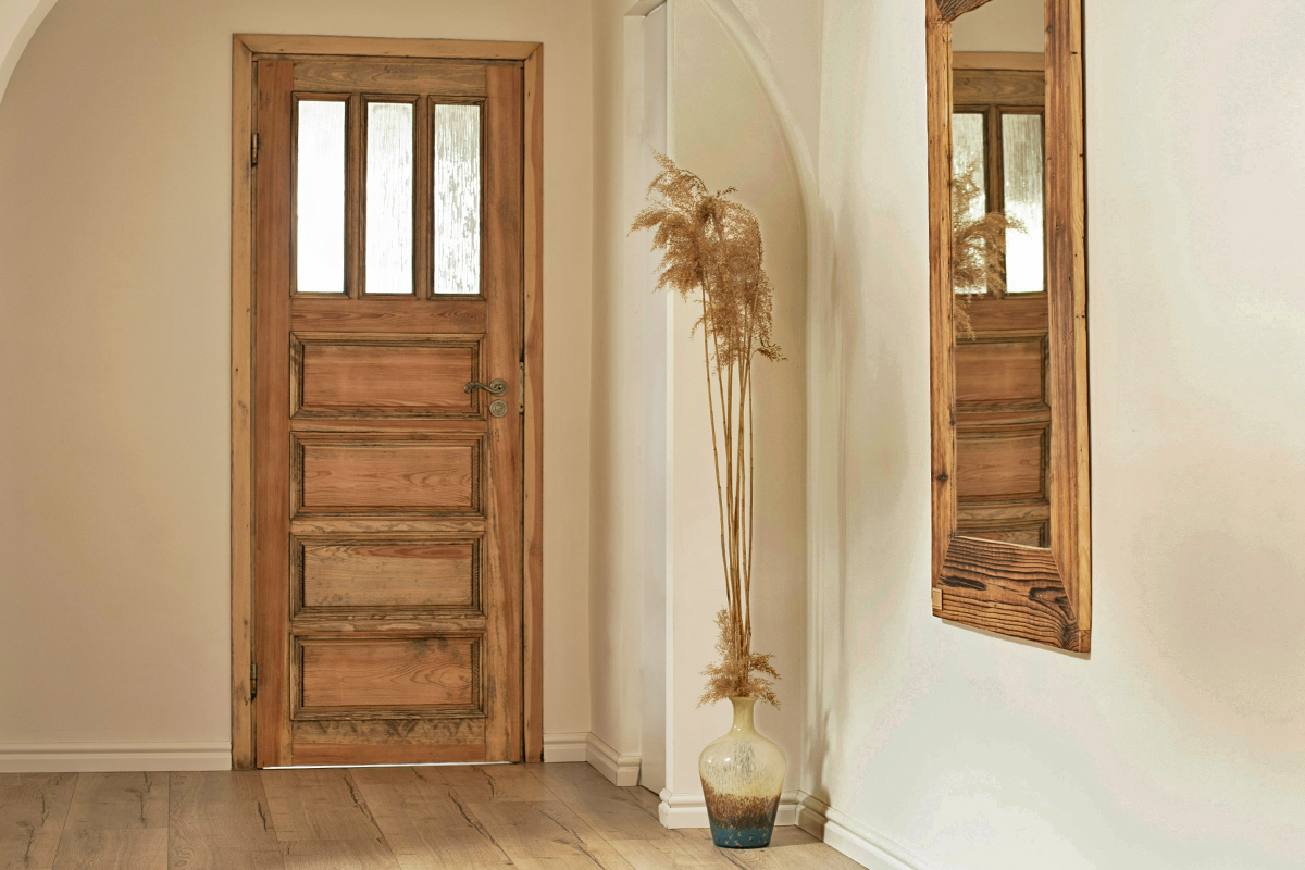 A vintage-looking wood front door with a slight gap under it.
