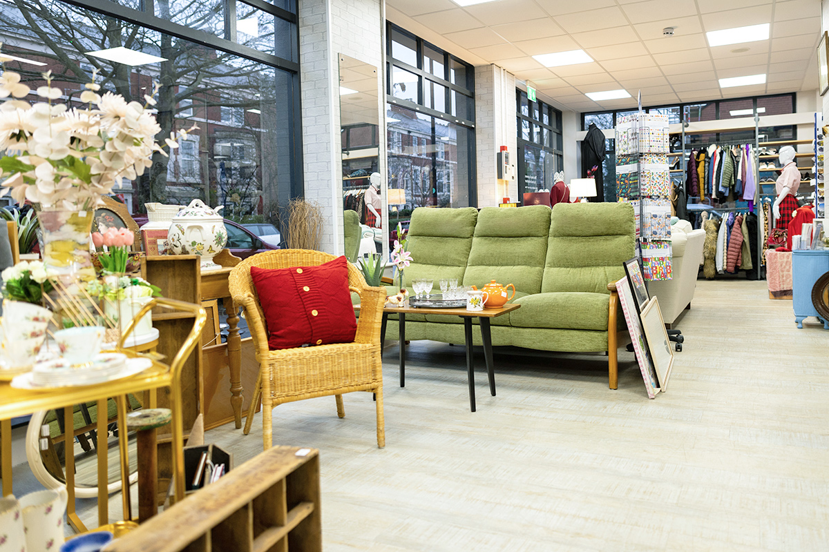 The interior of a thrift store that's displaying furniture, clothing, and home goods.